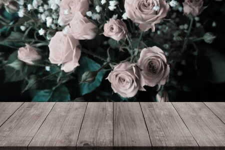 View from wooden table on wonderful bouquet of bush roses and gypsophila on a dark background. Selective focus. Shallow depth of field. Toned.の写真素材