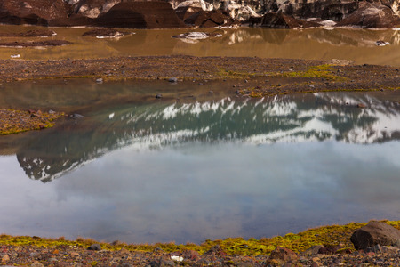 The stony rocky deserted landscape of Iceland. Reflection of mountain in the water.の写真素材
