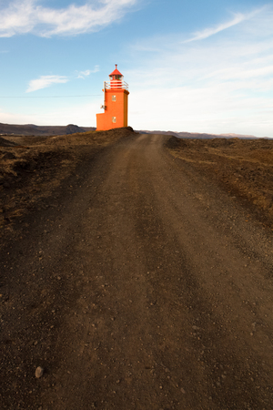 Orange lighthouse on a stony coast in Iceland. Toned.の写真素材