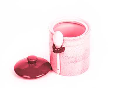 Light ceramic jar with spoon and cover on a white background. Toned.の写真素材