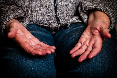 Hands of an old woman lying on her lap. Selective focus. Toned.の写真素材