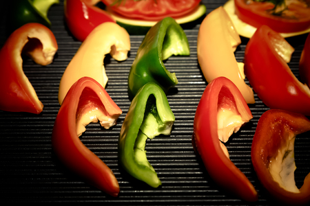 Slices of fresh vegetables on a grill pan surface. Selective focus. Shallow depth of field. Toned.の写真素材