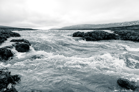 Water of stormy mountain river from waterfall - beautiful part of stony rocky desert landscape of Iceland. Toned.の写真素材