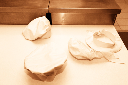 Professional chef hats on a professional table. Toned.の写真素材