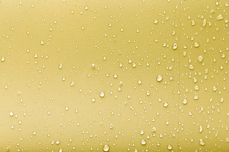 Drops of water on a color background. Yellow. Toned.の写真素材