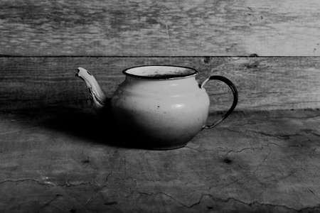 Metal dish on a wooden burned rustic texture for background. Rough weathered wooden board. Toned.の写真素材