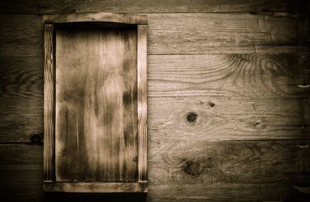 Handmade burned box on a wooden rustic texture for background. Rough weathered wooden board. Toned.の写真素材