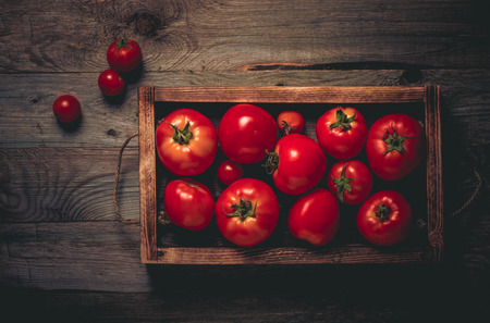 Fresh vegetables on a wooden burned rustic texture for background. Rough weathered wooden board. Toned.の写真素材