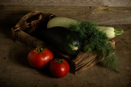 Fresh vegetables on a wooden burned rustic texture for background. Rough weathered wooden board. Toned.の写真素材