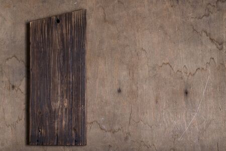 Handmade burned cutting board on a wooden rustic texture for background. Rough weathered wooden...
