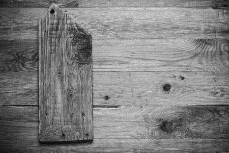 Handmade burned cutting board on a wooden rustic texture for background. Rough weathered wooden board. Toned.の写真素材