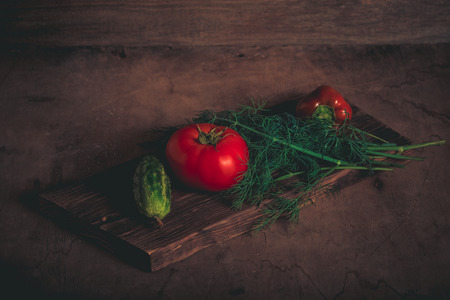 Fresh vegetables on a wooden burned rustic texture for background. Rough weathered wooden board. Toned.の写真素材