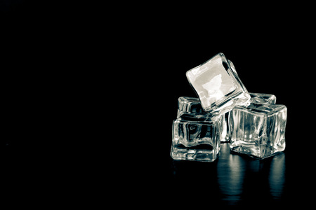Ice cubes on black background. Selective focus. Toned.の写真素材