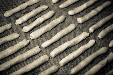 Fresh unbaked cheese sticks on a baking paper for background. Toned.の写真素材