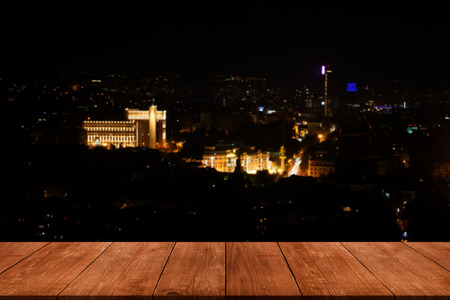 View from dark wooden gangway, table or bridge to the night Tbilisi. Collage.の写真素材