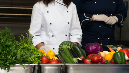 Set of fresh vegetables and herbs on a metal table of restaurant kitchen. Selective focus. Shallow depth of field.の写真素材