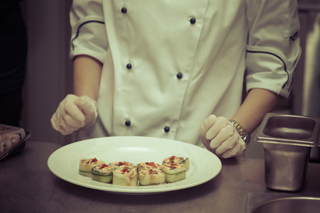 Chef is cooking set of sushi on a metal table of restaurant kitchen. Selective focus. Shallow depth of field. Toned.の写真素材