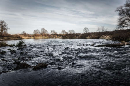 Beautiful view on a stormy river in the autumn. Toned.の写真素材