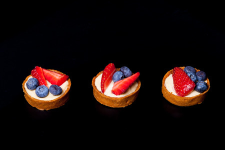 Berry tartlets with blueberries, strawberries and butter cream. Shallow depth of field. Selective...
