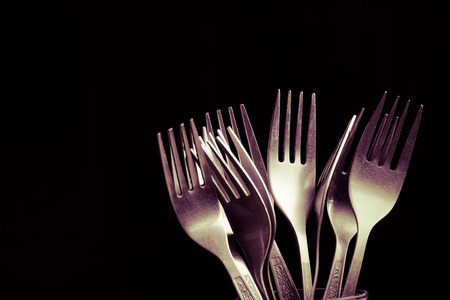 Lot of metal cutlery on a black background. Selective focus. Shallow depth of field. Toned.の写真素材