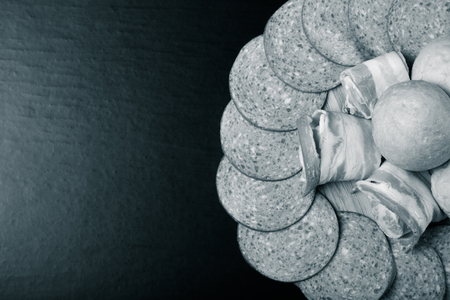 Sausage and bread on a dark  table. Shallow depth of field. Selective focus. Toned.の写真素材