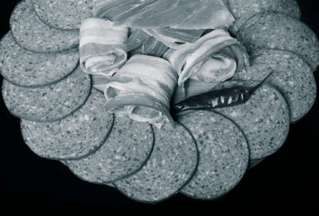 Different kinds of sausage on a dark  table. Shallow depth of field. Selective focus. Toned.