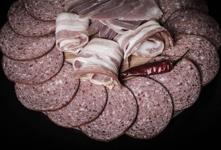 Different kinds of sausage on a dark  table. Shallow depth of field. Selective focus. Toned.
