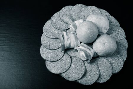 Sausage and bread on a dark  table. Shallow depth of field. Selective focus. Toned.の写真素材