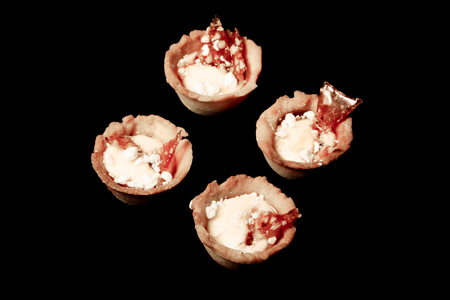 Tartlets with white cream and lemon curd on a black background. Shallow depth of field. Selective focus. Toned.の写真素材