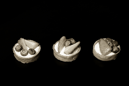 Berry tartlets with blueberries, strawberries and butter cream. Shallow depth of field. Selective focus. Toned.の写真素材