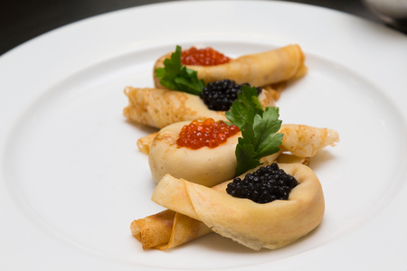 Pancakes with caviar on a white plate. Selective focus. Shallow depth of field.の写真素材