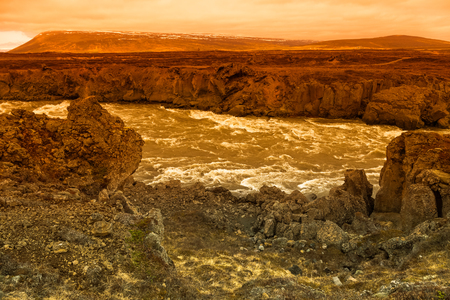 Water of the Godafoss Waterfall - beautiful part of stony rocky desert landscape of Iceland. Toned.の写真素材