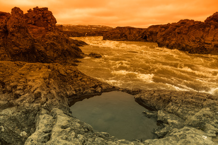 Water of the Godafoss Waterfall - beautiful part of stony rocky desert landscape of Iceland. Toned.の写真素材