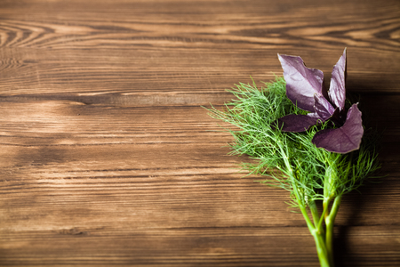 Dill and basil on old wood boardの写真素材