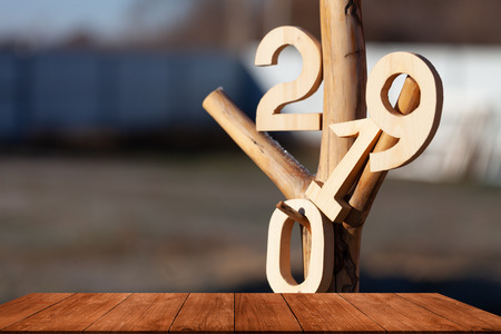 Wooden table. In the background, the numbers 2019 hang on the knots of a treeの写真素材