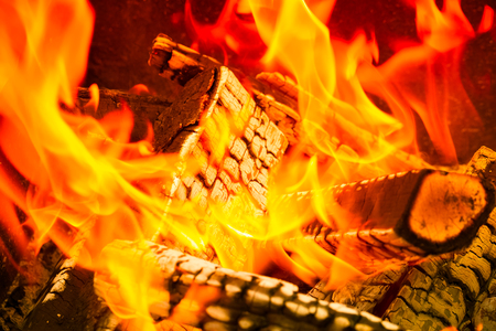 Burning wood logs, cooking on fire, warm evening, sparkles in the air, warm air from the fireの写真素材