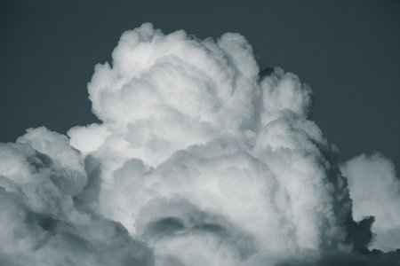 Blue sky with white cumulus clouds. Toned.の写真素材