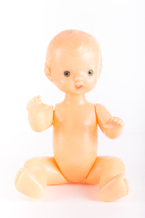 Old plastic doll on a light background.の写真素材