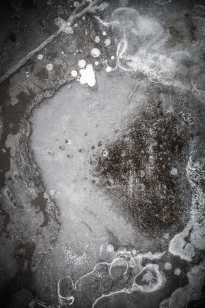 Abstract pattern of ice on the over of puddle. Toned.の写真素材