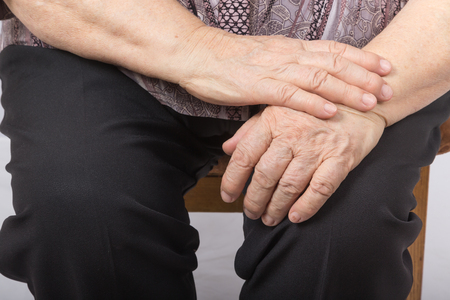 Hands of an old woman lying on her lap.の写真素材