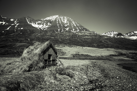 Small wooden house with grass roof in the Iceland fjord. Toned.の写真素材