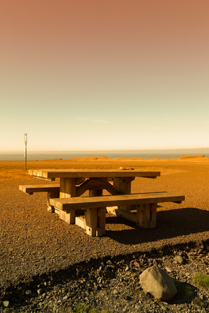 Wooden bench and table on a beautiful multicolored spring landscape of Iceland. Toned.の写真素材