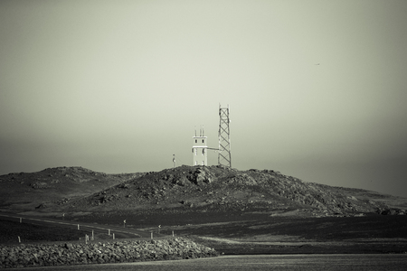 Technical building and metal tower on a hill on the coast. Iceland fjords. Toned.の写真素材