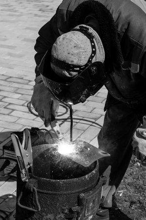 An experienced welder at work. Preparation and welding process of cast iron furnace. Selection focus. Shallow depth of field. Toned.の写真素材