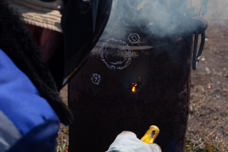 An experienced welder at work. Preparation and welding process of cast iron furnace. Selection...
