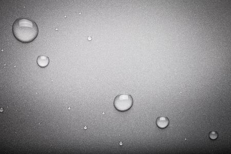 Drops of water on a color background. Dark grey. Toned.の写真素材