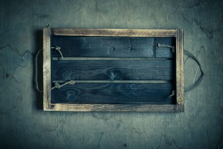 Handmade burned box on a wooden rustic texture for background. Rough weathered wooden board. Toned.の写真素材