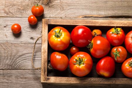Fresh vegetables in a burned rustic texture box for background. Rough weathered wooden board.の写真素材