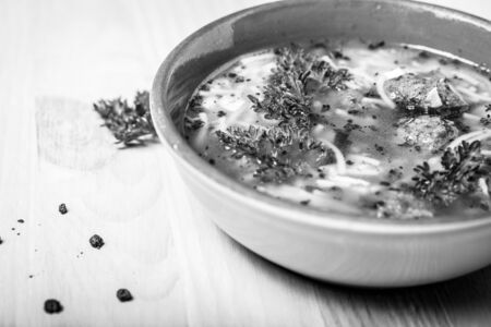 Homemade soup with noodles and meatballs on a wooden table. Traditional rural dinner. Toned.の写真素材
