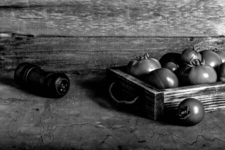 Fresh vegetables in a burned rustic texture box for background. Rough weathered wooden board. Toned.の写真素材